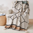 Plaid tricoté style bohème motifs géométriques avec pompons