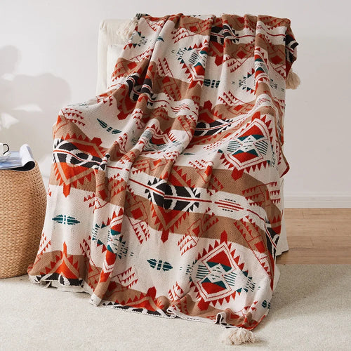 Plaid tricoté style bohème motifs géométriques avec pompons