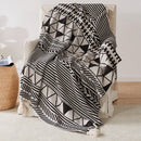 Plaid tricoté style bohème motifs géométriques avec pompons
