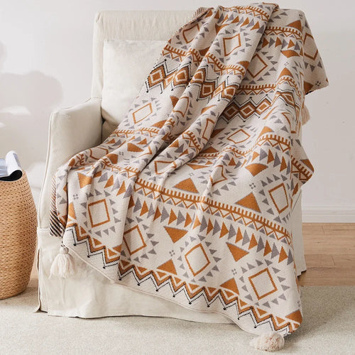 Plaid tricoté style bohème motifs géométriques avec pompons